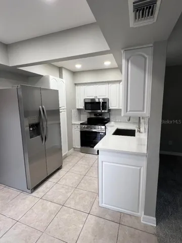 Kitchen with new stainless steel appliances.