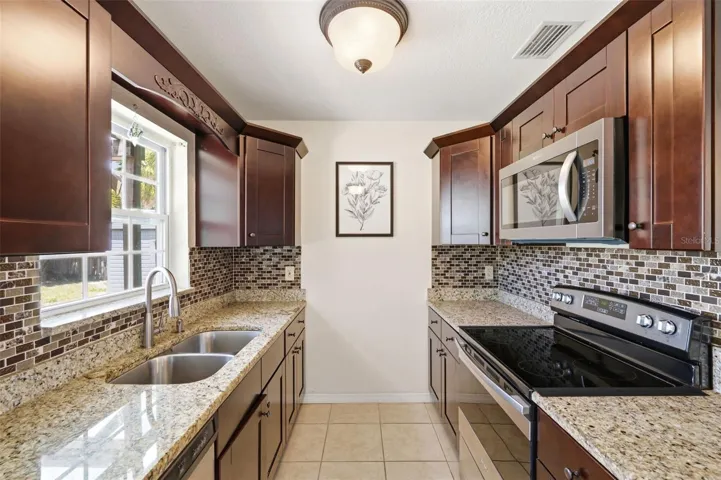 Bright Kitchen with window above sink letting sunshine in and providing a view of the Backyard.