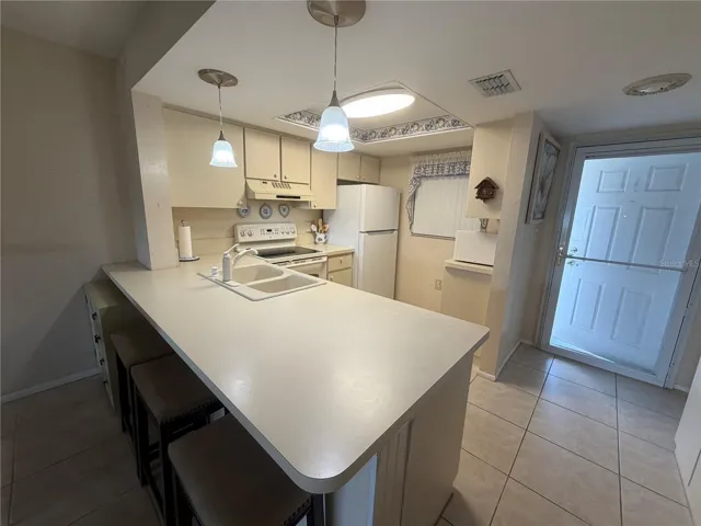 Kitchen with newer refrigerator, Tile flooring
