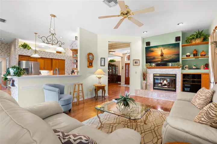Open to the kitchen, the family room features hardwood flooring, built-in accents, and a wood-burning fireplace.