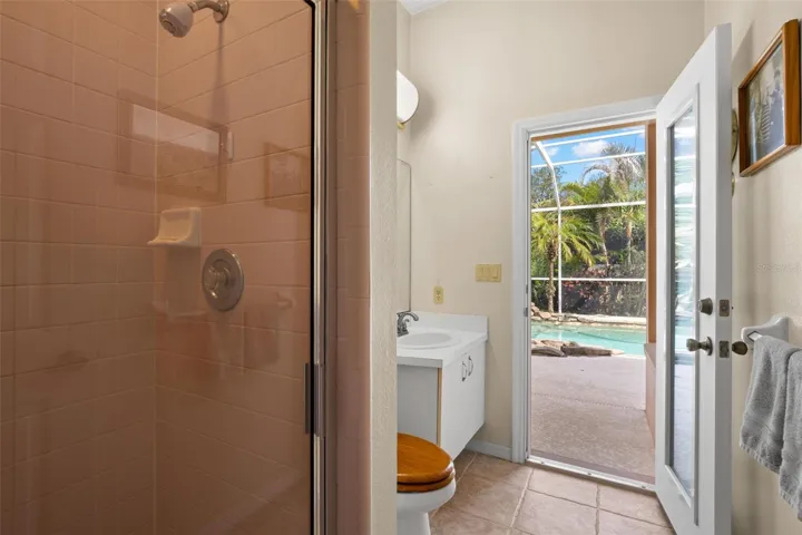 The third bath includes a walk-in shower and convenient direct access to the screened pool and lanai.