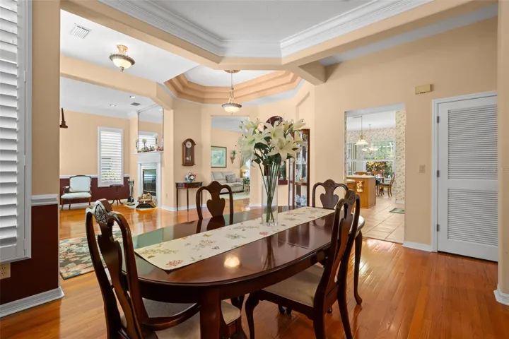 Architectural ceiling details, hardwood flooring, and seamless sightlines to adjoining living spaces showcase the home's spacious layout.