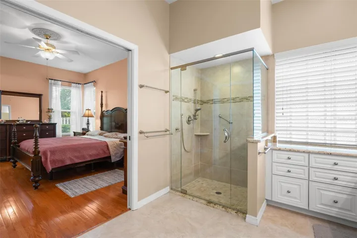 The spacious walk-in shower features a glass enclosure, tile surround, and convenient access from the primary suite.