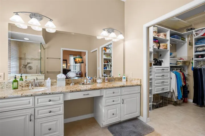 The primary bath includes a dedicated makeup vanity, granite countertops, and direct access to the walk-in closet.