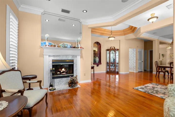 A wood-burning fireplace with a marble surround serves as a focal point of the living room, while open sightlines showcase the home's spacious layout.