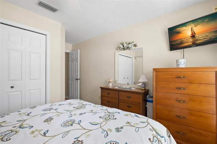 Neutral finishes, carpet, a built-in closet and a ceiling fan create a comfortable and inviting third bedroom.