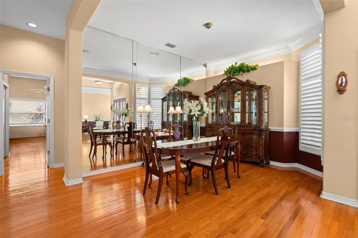 Hardwood flooring, crown molding, chair rail detailing, and plantation shutters add warmth and character to the formal dining room.