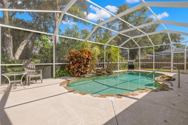 Surrounded by tropical landscaping and mature trees, the screened pool provides a private setting for enjoying Florida's outdoor lifestyle.
