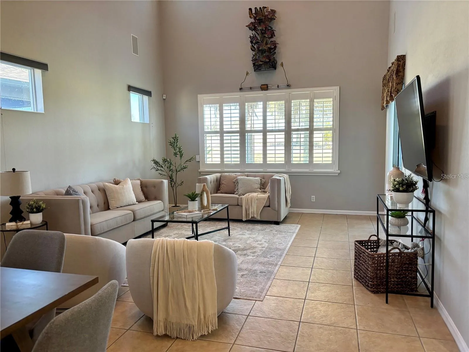 Living Room with plantation shutters and TV and surround sound stays.