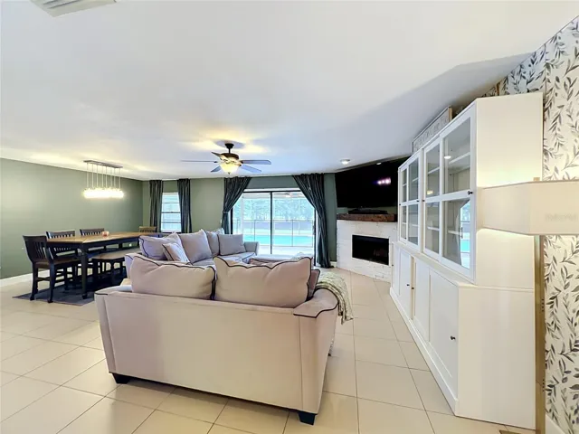 Dining/family room with a wood burning fireplace and sliders out to the screened-in pool.