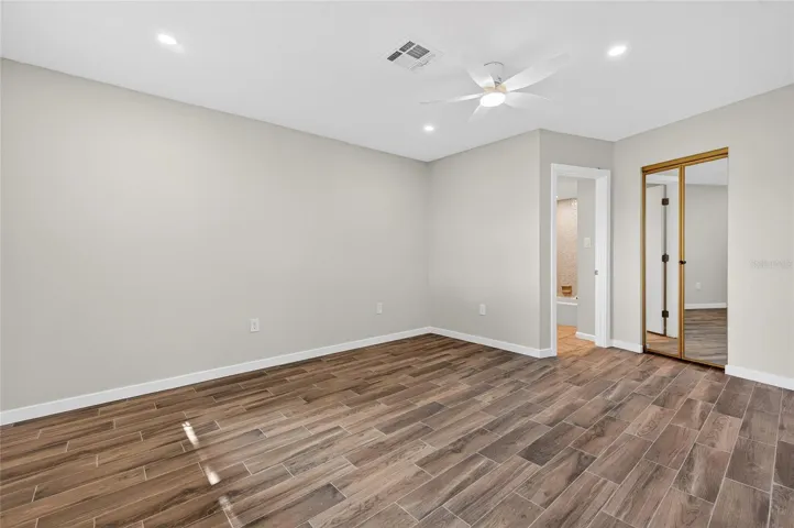 Primary bedroom with ensuite bathroom & walk-in closet.  New tile flooring, lights and ceiling fan!