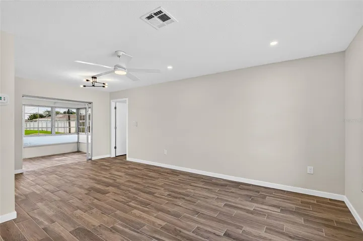 Front living room and dining with brand new tile flooring, paint, AC vents and lighting!
