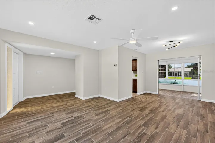 Front living room and dining with brand new tile flooring, paint, AC vents and lighting!