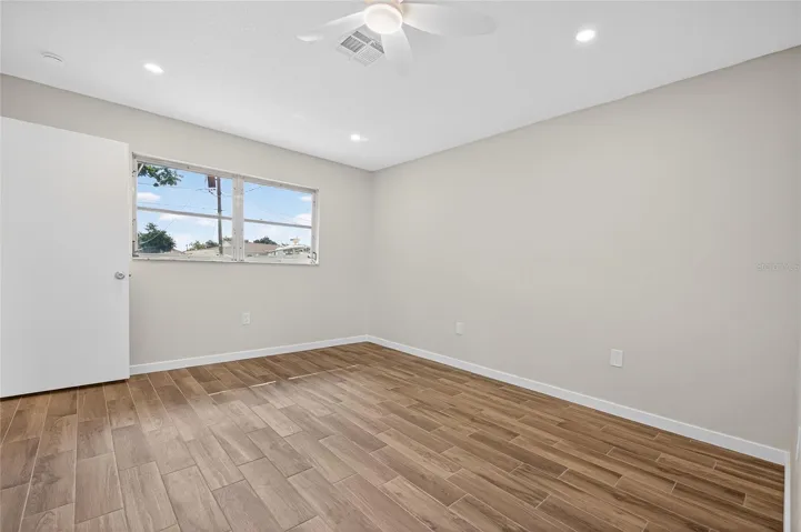 Primary bedroom with ensuite bathroom & walk-in closet.  New tile flooring, lights and ceiling fan!