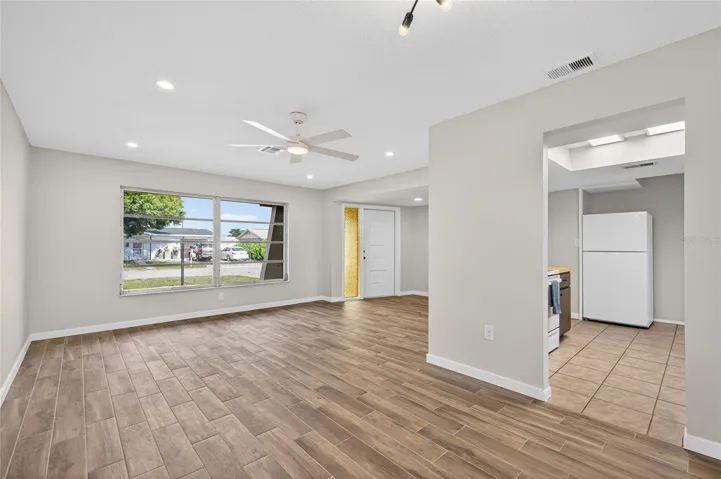 Front living room and dining with brand new tile flooring, paint, AC vents and lighting!