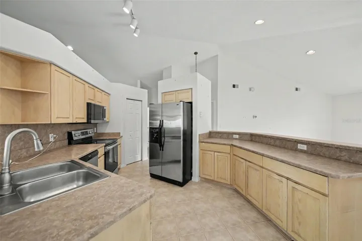 Good size kitchen with wood cabinets, stainless steel appliances and pantry closet
