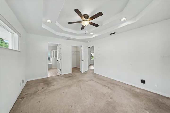 Large size primary bedroom with walk-in closet and sliding door to pool deck