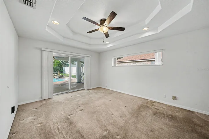 Large size primary bedroom with walk-in closet and sliding door to pool deck