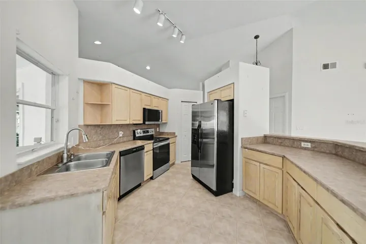 Good size kitchen with wood cabinets, stainless steel appliances and pantry closet