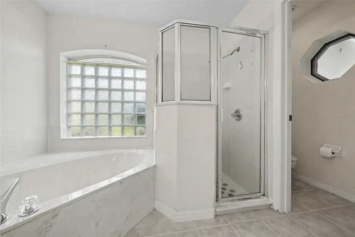 Primary bathroom with double sink vanity and separate shower and separate tub and commode room