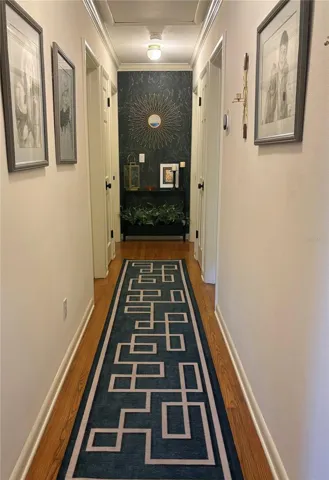 Hallway leading to full bath and three bedrooms
