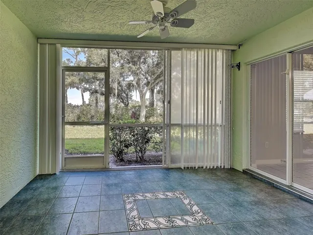 Lanai (note tiled floor with mosaic inlay), vinyl sliders, back yard