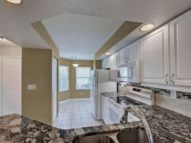 Looking across breakfast bar into kitchen and breakfast nook