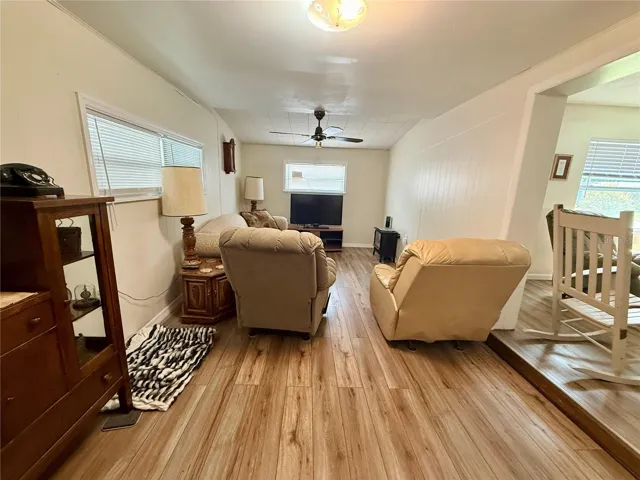 Living room featuring laminate flooring, ceiling  fan and new double pane windows