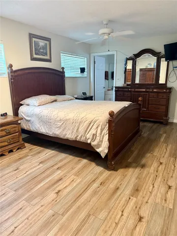 Primary bedroom featuring new laminate flooring, ceiling fan