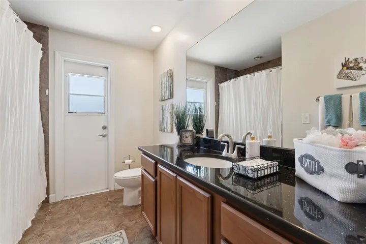 The hall bath, which also serves as the pool bath, is conveniently located between Bedrooms #2, #3, and #4. Access to the pool bath is from the covered lanai, allowing swimmers to go directly from the pool to the bathroom without tracking water through the house.