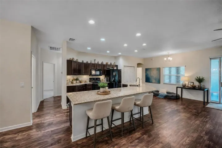 Virtually staged kitchen with granite counters and wood cabinets.