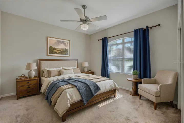 To the right of the front entry is a bedroom with carpet and ceiling fan which is virtually staged.