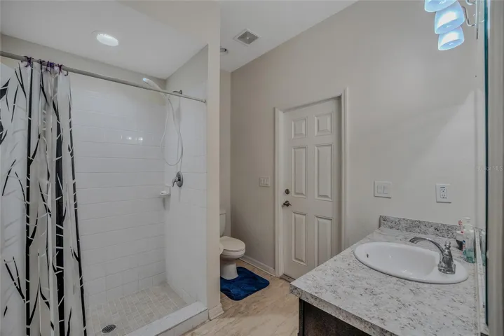 Guest bath with shower and tile floor.