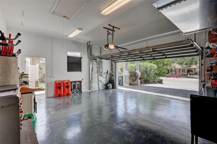 Garage equipped with Tesla charging station and epoxy floors.