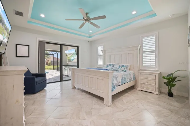 Primary Suite Features High Impact Slider Leading To Lanai/Pool