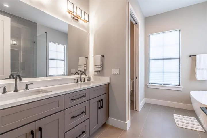 Twin sink vanity and water closet in the primary bath.
