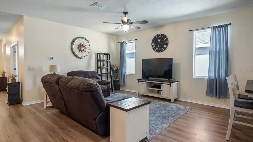 Living room with two windows that provide natural light and new luxury vinyl plank flooring throughout.