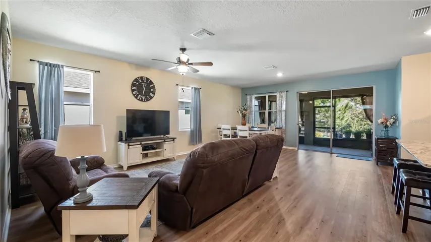 Living room with two windows that provide natural light and new luxury vinyl plank flooring throughout.