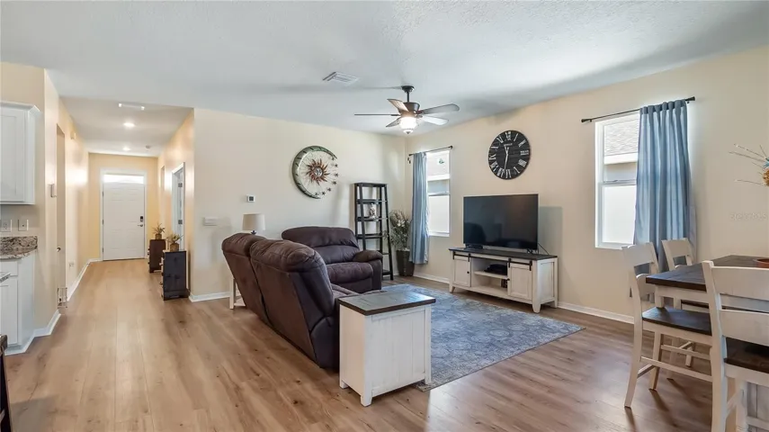 Living room with two windows that provide natural light and new luxury vinyl plank flooring throughout.
