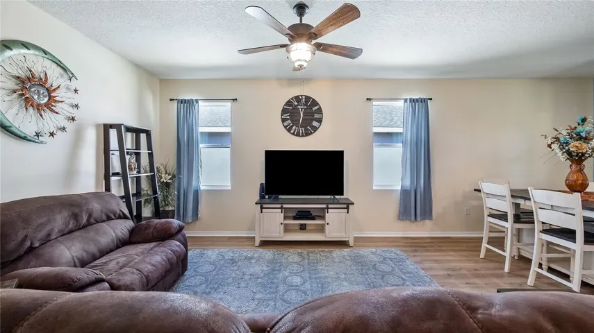 Living room with two windows that provide natural light and new luxury vinyl plank flooring throughout.