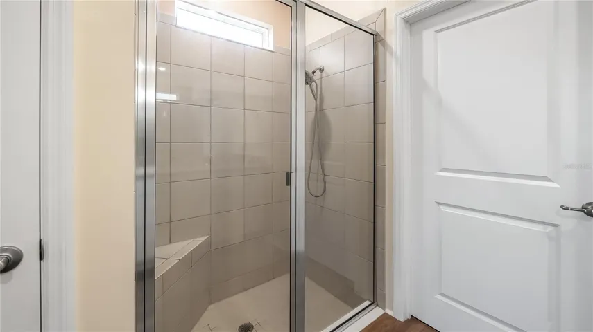 Primary bathroom with dual vanity and walk-in closet and shower.