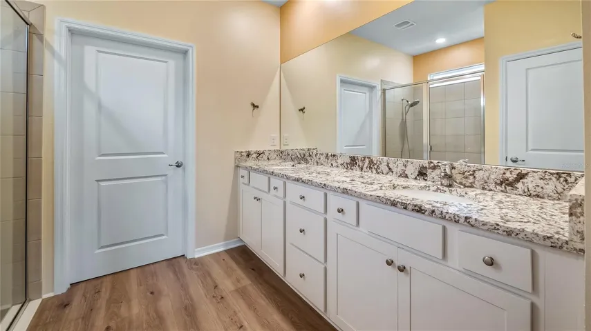 Primary bathroom with dual vanity and walk-in closet and shower.