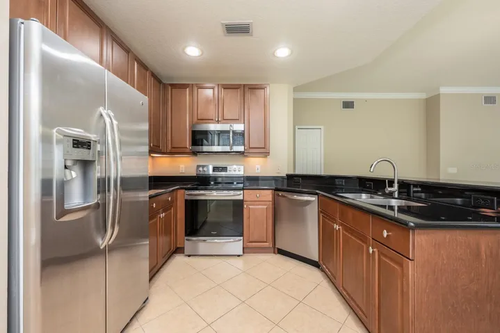 The kitchen blends style and comfort with UPDATED STAINLESS STEEL APPLIANCES, newer fixtures, pantry storage, a BUILT-IN BREAKFAST NOOK surrounded by windows, and a breakfast bar that is ideal for casual dining or entertaining!