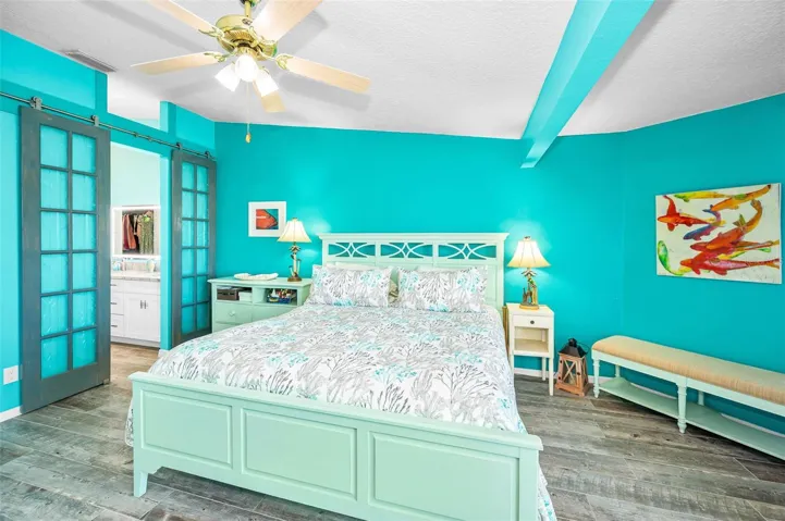 Primary bedroom with decorative barn door to the bathroom