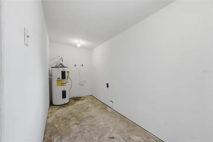 Utility room with washer and dryer hook up and room for storage racks.