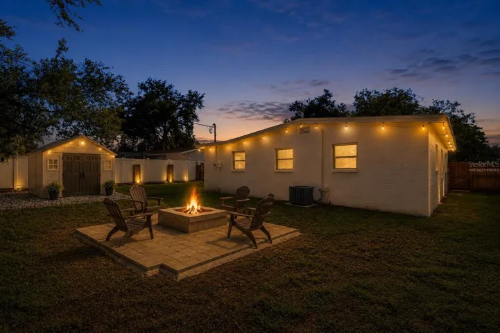 Virtually staged backyard with a shed and lighting.