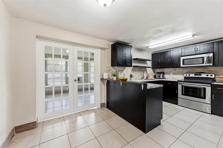 Kitchen with double doors that lead back to the third bedroom. This can also be used as an office, Florida room or extra living room. Endless possiblities.