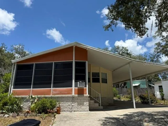 Large double wide | front enclosed cooled porch | covered parking + circular drive.