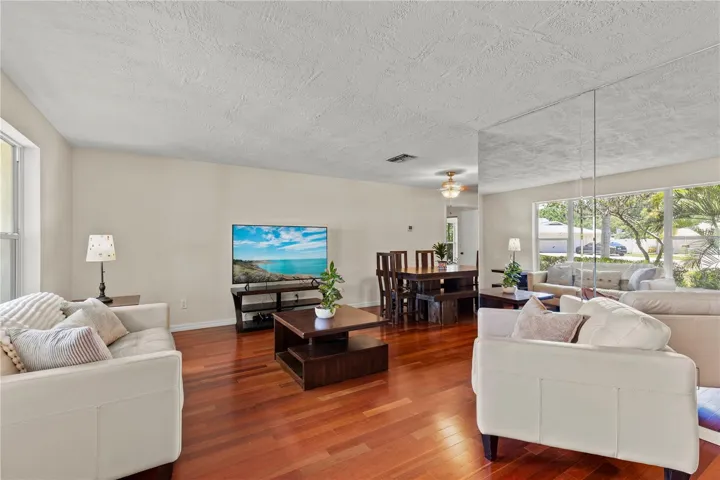 Bright and inviting living room featuring a large picture window that fills the space with abundant natural light, creating a warm and welcoming atmosphere