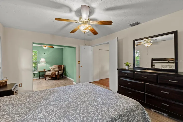 Spacious primary bedroom retreat featuring a bright and airy layout with a comfortable sitting area, creating the perfect space for relaxation and privacy. The room offers abundant natural light and a peaceful atmosphere, ideal for an owner’s suite designed for comfort and everyday living.